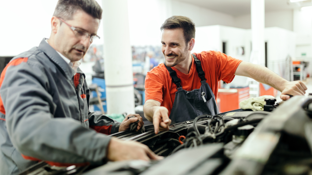 Two mechanics working on car